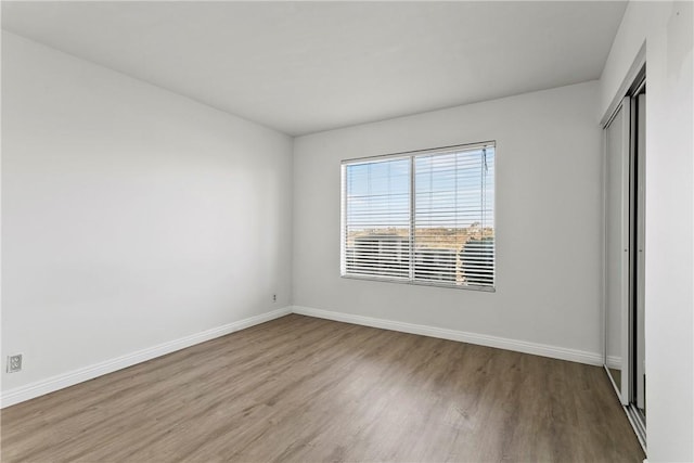 unfurnished bedroom with light hardwood / wood-style flooring and a closet