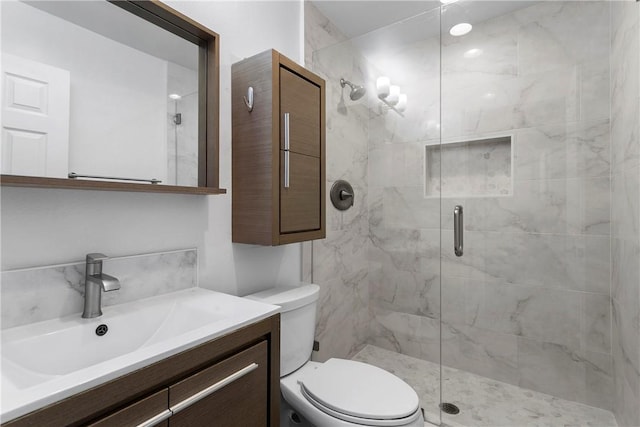 bathroom with an enclosed shower, vanity, and toilet