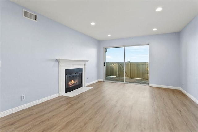 unfurnished living room with light wood-type flooring and a fireplace