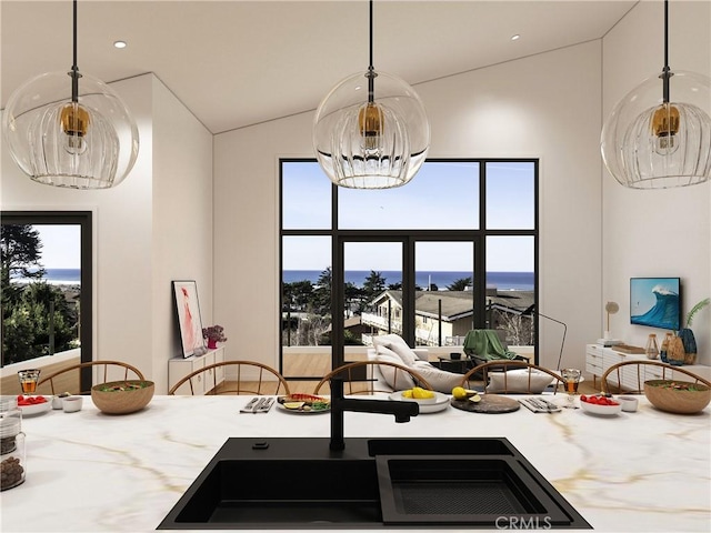 kitchen featuring vaulted ceiling, a wealth of natural light, a chandelier, and pendant lighting