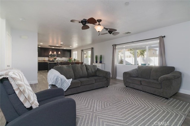 living room with ceiling fan and hardwood / wood-style floors