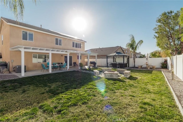 rear view of property featuring a gazebo, a lawn, and a patio