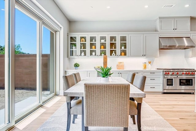 dining area with light wood-type flooring, visible vents, and recessed lighting