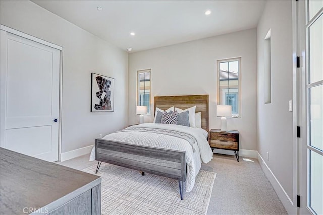 bedroom featuring recessed lighting, light colored carpet, and baseboards