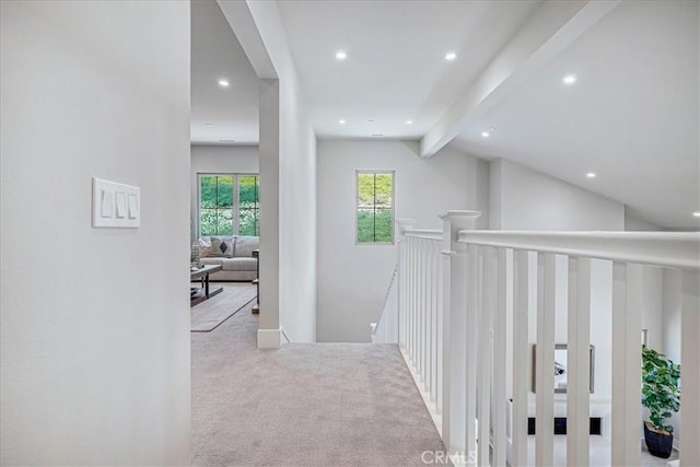 hall featuring lofted ceiling with beams, recessed lighting, an upstairs landing, and light colored carpet