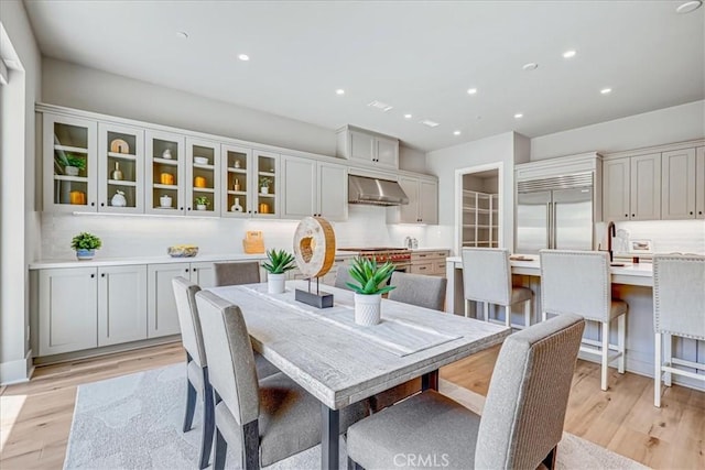 dining area with sink and light hardwood / wood-style floors