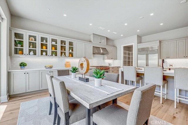 dining area with light wood-type flooring and recessed lighting