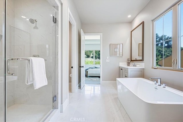 ensuite bathroom with a freestanding tub, connected bathroom, vanity, baseboards, and a stall shower