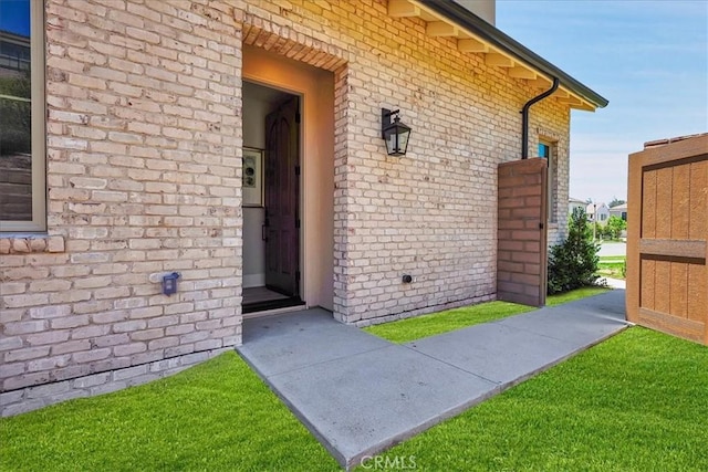 view of home's exterior featuring brick siding and a yard