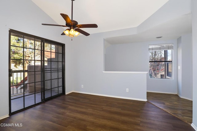 empty room with vaulted ceiling, ceiling fan, and dark hardwood / wood-style flooring