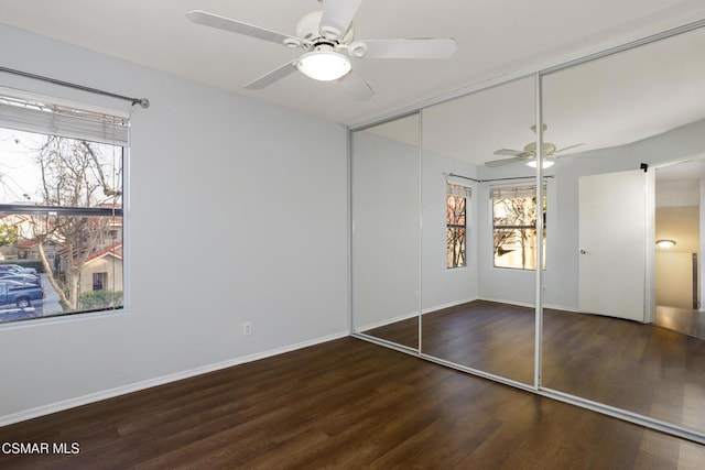 unfurnished bedroom with ceiling fan, a closet, and dark hardwood / wood-style floors