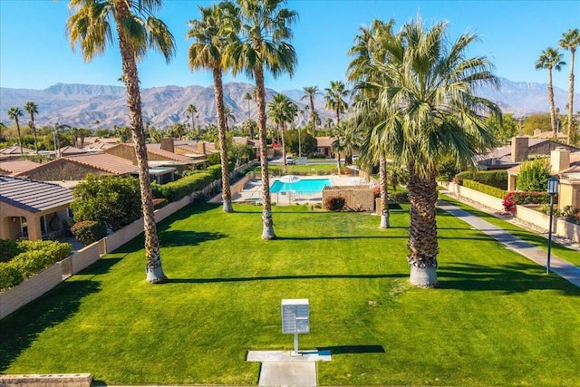 view of home's community featuring a mountain view, a swimming pool, and a lawn