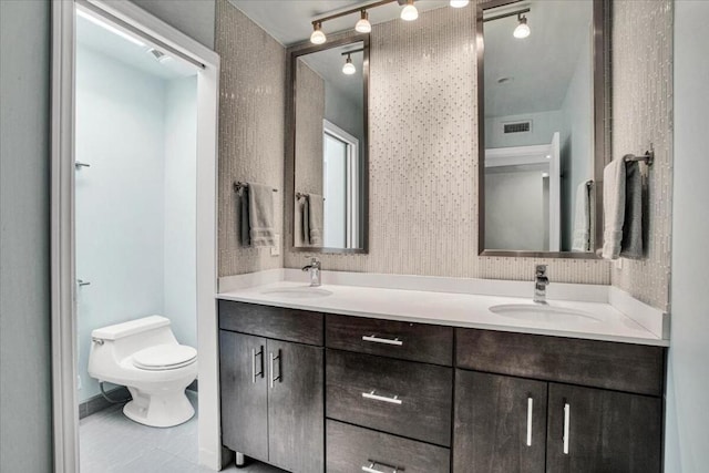 bathroom featuring tile patterned flooring, vanity, and toilet