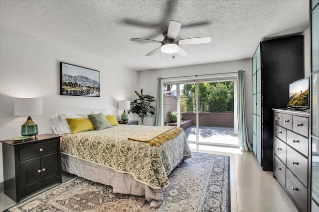 bedroom featuring access to outside, a textured ceiling, and ceiling fan