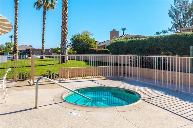 view of pool with a lawn, a hot tub, and a patio