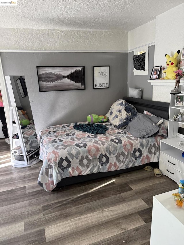 bedroom with a textured ceiling and dark wood-type flooring