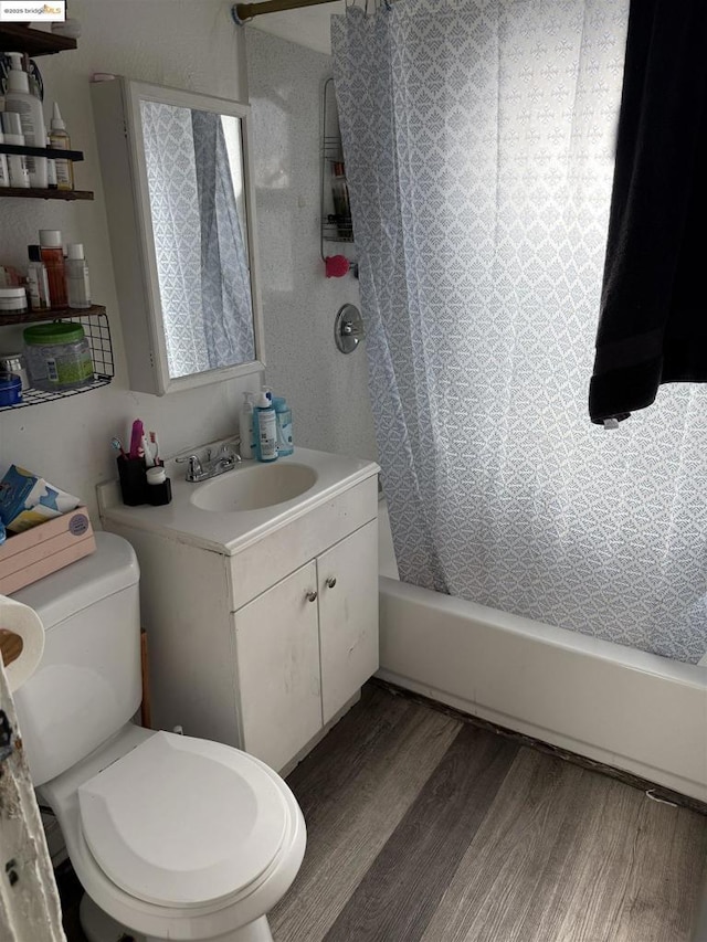 full bathroom with toilet, vanity, shower / tub combo, and hardwood / wood-style flooring