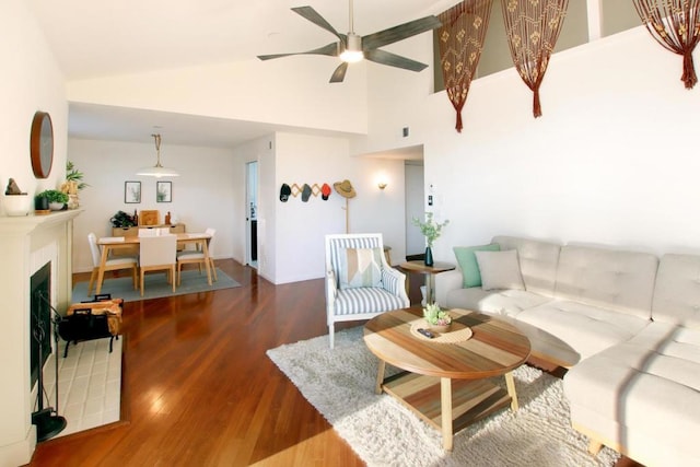 living room with ceiling fan, vaulted ceiling, and hardwood / wood-style flooring