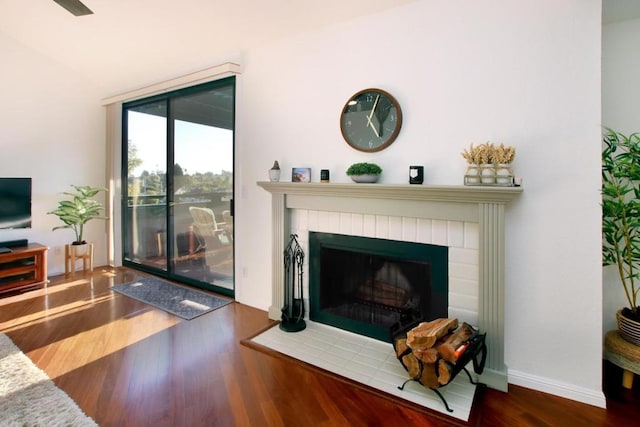 living room with dark wood-type flooring and a fireplace