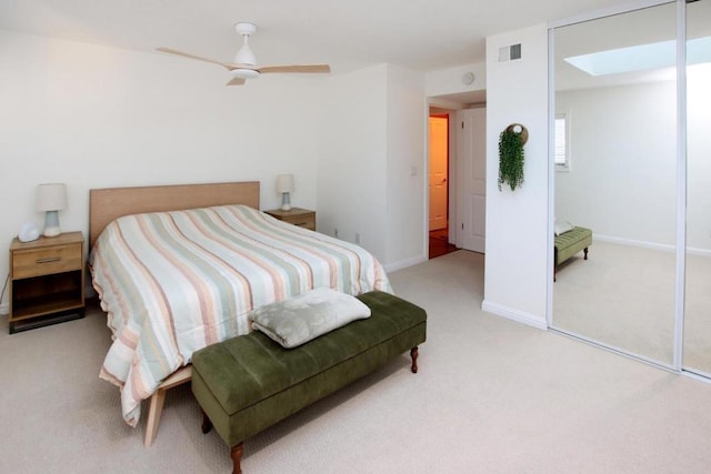 carpeted bedroom with ceiling fan and a skylight