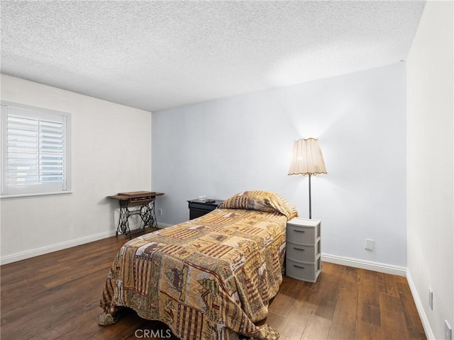 bedroom featuring a textured ceiling and dark hardwood / wood-style flooring