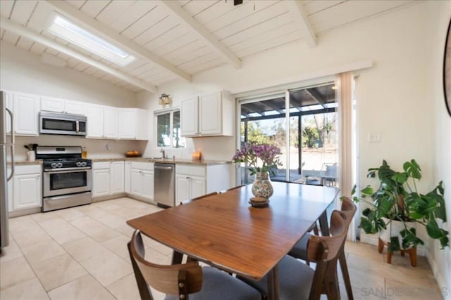 kitchen featuring stainless steel appliances, sink, light tile patterned floors, and white cabinets