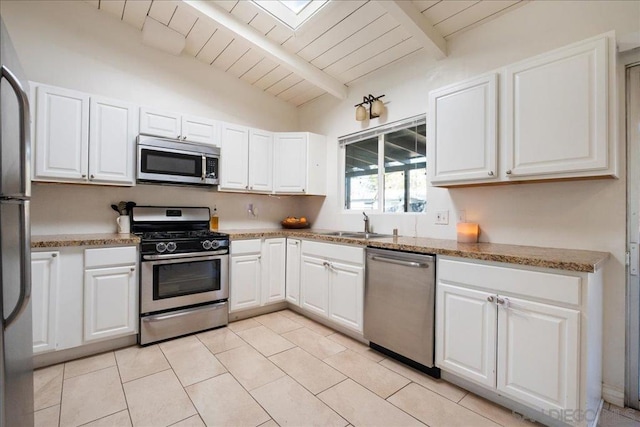 kitchen with light tile patterned floors, appliances with stainless steel finishes, vaulted ceiling with beams, white cabinets, and wooden ceiling