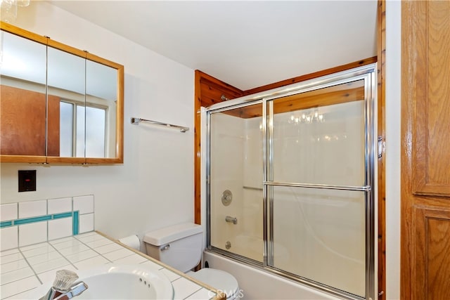 full bathroom featuring vanity, shower / bath combination with glass door, and toilet