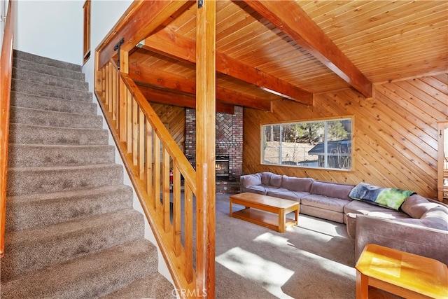 carpeted living room with wood ceiling, wooden walls, and beam ceiling