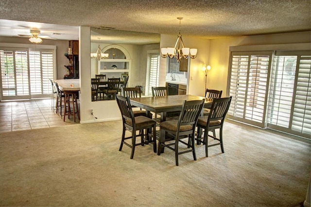 carpeted dining area featuring ceiling fan with notable chandelier and a textured ceiling