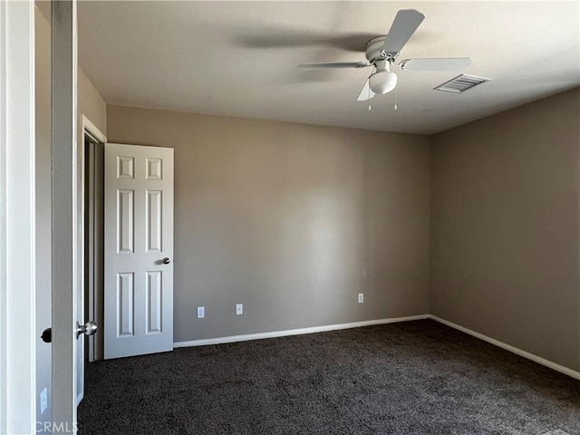 spare room with ceiling fan and dark colored carpet