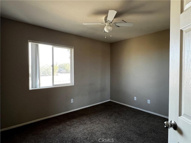 unfurnished room featuring ceiling fan and dark carpet