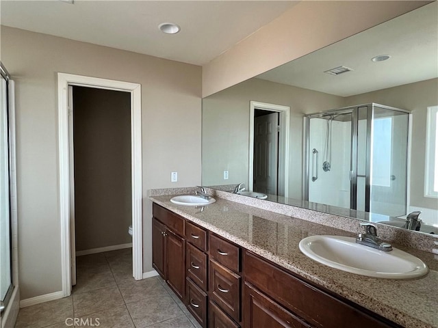 bathroom with a shower with shower door, toilet, vanity, and tile patterned flooring