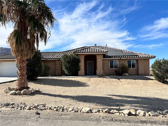 view of front facade featuring a garage and solar panels