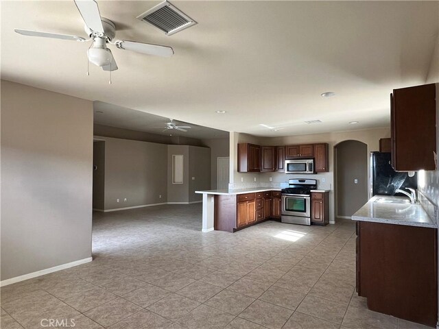 kitchen with kitchen peninsula, ceiling fan, sink, light tile patterned flooring, and stainless steel appliances