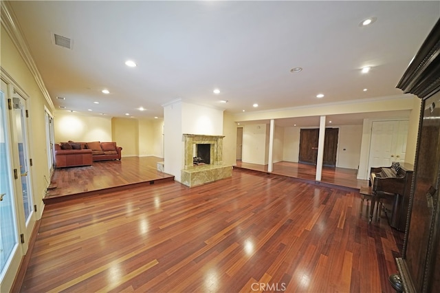 living room featuring hardwood / wood-style flooring, ornamental molding, and a high end fireplace