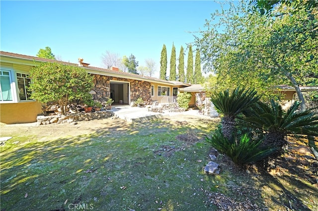 back of house with a yard and a patio