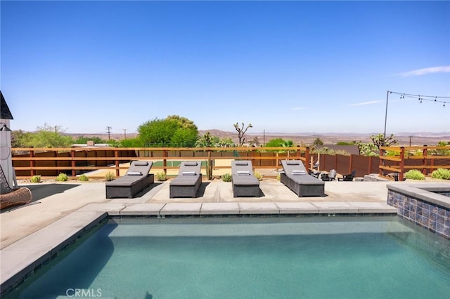 view of swimming pool with a mountain view and a patio area