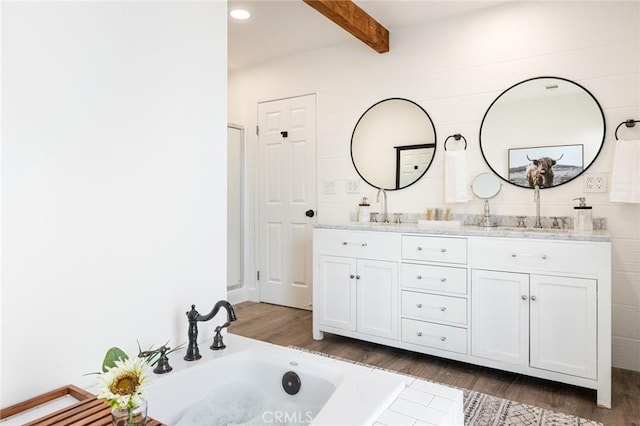 bathroom featuring wood-type flooring, a bath, beamed ceiling, and vanity