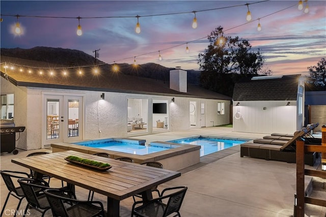 view of pool featuring an in ground hot tub, a patio, french doors, and a grill