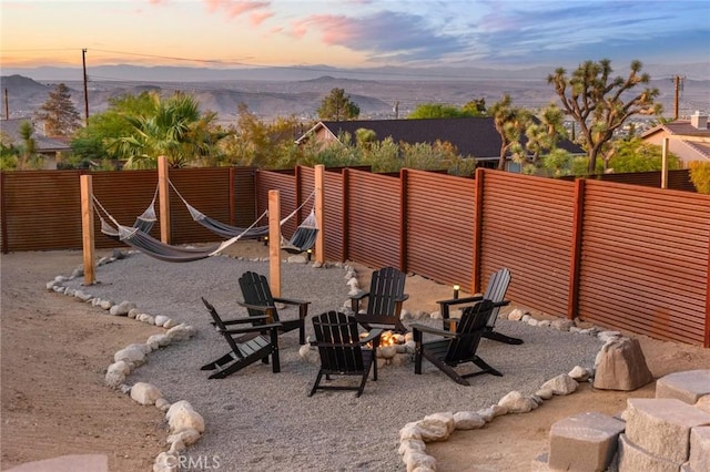 patio terrace at dusk with a mountain view and a fire pit