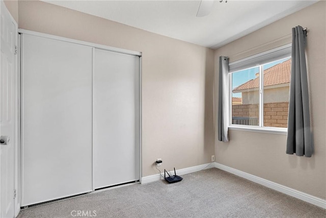 unfurnished bedroom with a closet, ceiling fan, and carpet