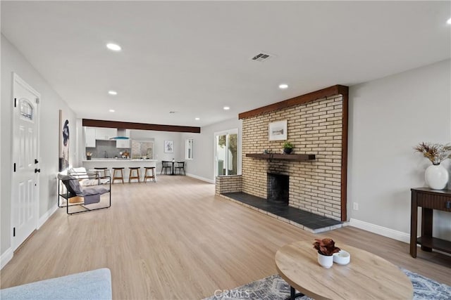 living room featuring a fireplace and light wood-type flooring