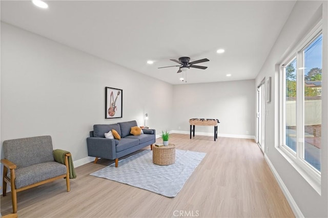 living room featuring ceiling fan and light hardwood / wood-style flooring