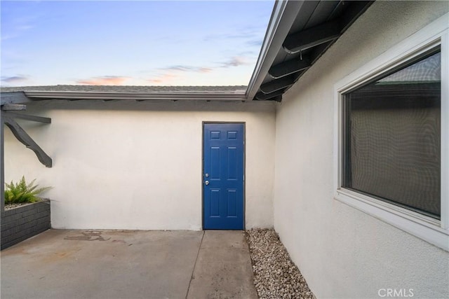 exterior entry at dusk with a patio