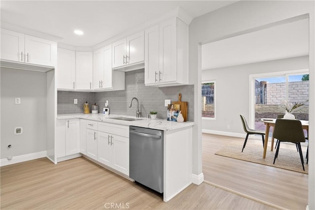 kitchen featuring stainless steel dishwasher, sink, light hardwood / wood-style flooring, and white cabinets