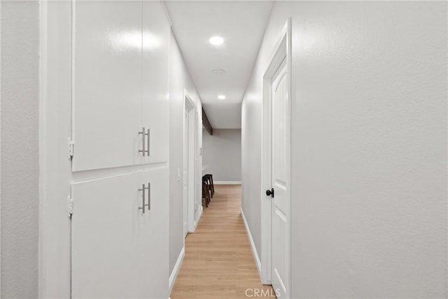 corridor with light hardwood / wood-style floors