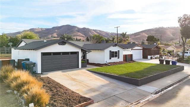 single story home with a garage, a mountain view, and a front yard