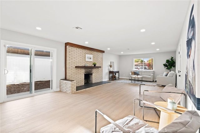 living room featuring light hardwood / wood-style floors and a brick fireplace