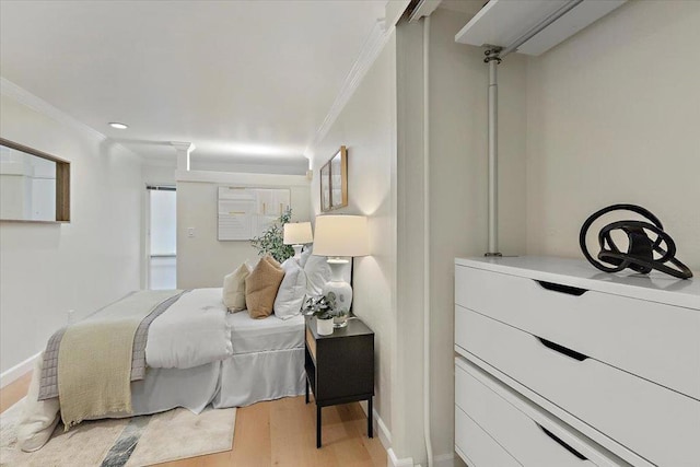 bedroom with crown molding and light hardwood / wood-style floors